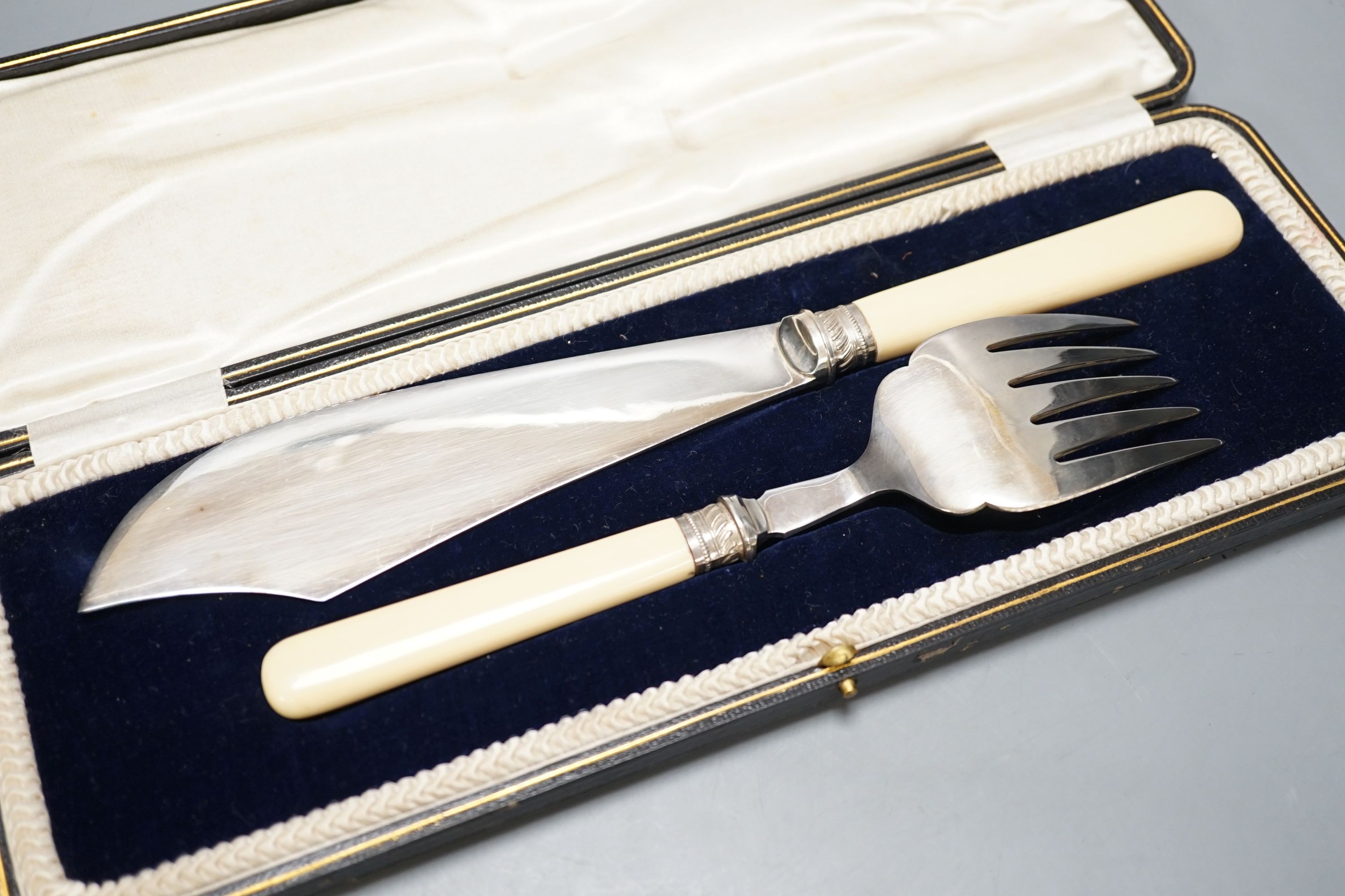 A cased pair of ivory handled silver plated fish servers.